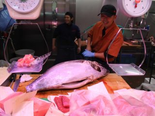Cutting up tuna for sale in front of the customers