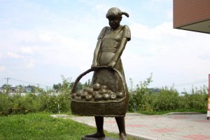 Statue of a girl with a bucket of apples