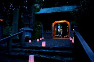 Lanterns in front of and past the temple gate glowing