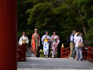Foreign tourists and Japanese women in yukata were crossing the red bridge that stood next to Taiko-bashi