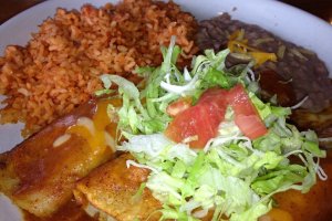 The enchilada plate is a bit spicy and comes with three enchiladas topped with lettuce, refried beans, and Mexican rice