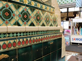 The wall is covered with colourful Majolica tiling