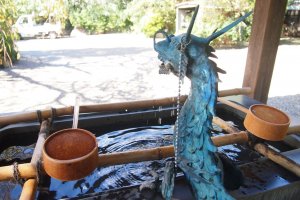 The beautiful blue-green dragon on the purification trough. The ladle is used to rinse both hands as well as mouth in the purification ritual.