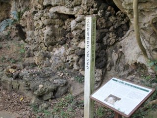 A small placard in English and Japanese next to the tomb details the importance of the site