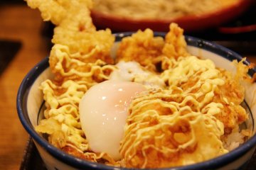<p>ไข่ ค่อยๆไหลลงไปตามช่องว่าง ใช้ตะเกียบเจาะให้ไข่แดงกระจายไหลเยิ้มซึมและเคลือบเม็ดข้าวเห็นเป็นสีส้มสดใส พร้อมแล้วที่จะกิน</p>