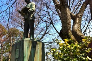 Statue of Saneyuki Akiyama in a grove of cherry trees