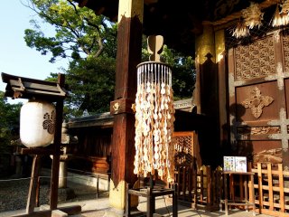 Gentle breeze flutters gourd-shaped Ema (wish plaques) hanging from Kara-Mon gate