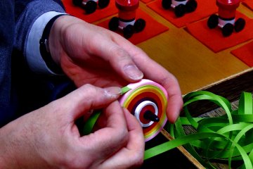 <p>This is how you make Kyo Koma (Kyoto Spinning Tops). How tight/loose you wind it is the key to success, the Maestro says. When the balance is wrong, the top won&#39;t spin at all!</p>