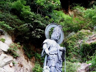 Bức tượng quan âm bồ tát với những tảng đá trần của núi Asuwa ở xung quanh phía sau