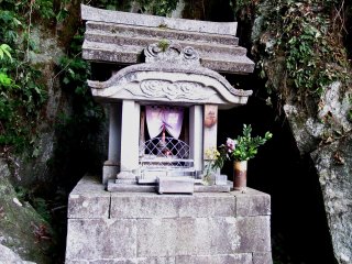 Small stone shrine in the shadow of the mountain cave