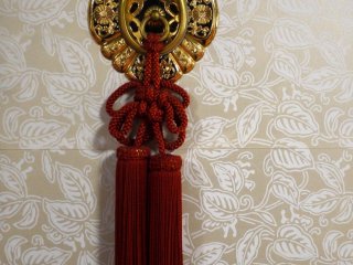 Red tassels decorate an ornate finger plate on a sliding door