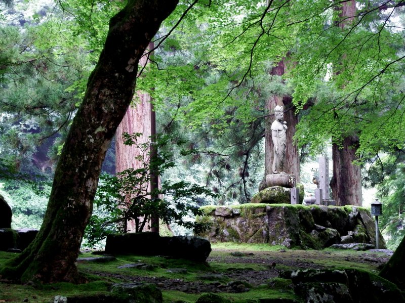 <p>Statue of Goddess of Mercy in a green forest</p>