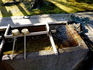 Một tượng rồng nhỏ nằm bên cạnh bể nước rửa tay