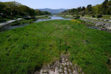 <p>Kamogawa flows from the blue hills north of Kyoto all the way to southern Kyoto</p>