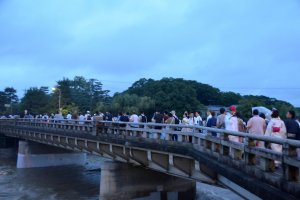 Malgr&eacute; le ciel maussade, une foule de spectateurs se dirige vers les rives de la rivi&egrave;re Kamogawa