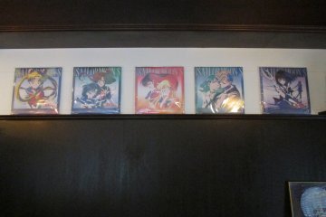 <p>Sailor Moon posters over a table</p>