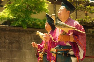<p>These men hold wooden birds representing traditional Japanese Falconry, or Takagari which is a practice that is associated with status and nobility.</p>
