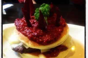 <p>The Maestro: two pancakes stuffed with a hamburger, onions, and cheese, topped with chili sauce</p>
