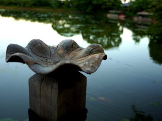 A carved wooden bowl like a lotus leaf at the end of the pier