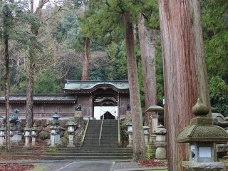 参道が左に折れると回廊に囲まれた社殿を中に持つ神門が見える