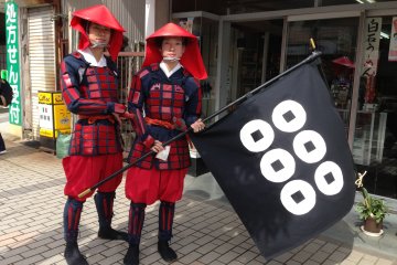 <p>Two members of the Sanada clan pose with their battle flag.</p>