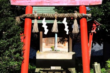 <p>Brilliant red torii gate stands out in the otherwise plain temple grounds</p>
