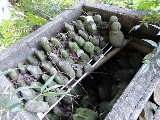 稲荷神社の横にある古井戸が、壊れた地蔵の墓地になっている