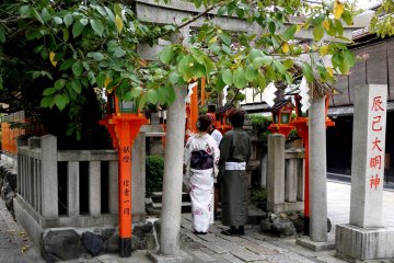 <p>Парочка в кимоно зашла помолиться в храм Татцуми Даимёдзин</p>