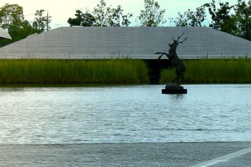<p>Скульптура скачущего оленя посреди водоема</p>