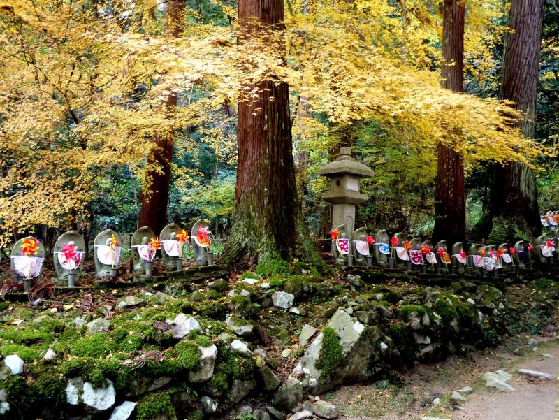 <p>Yellow maple leaves spread over the statues like a golden blessing</p>