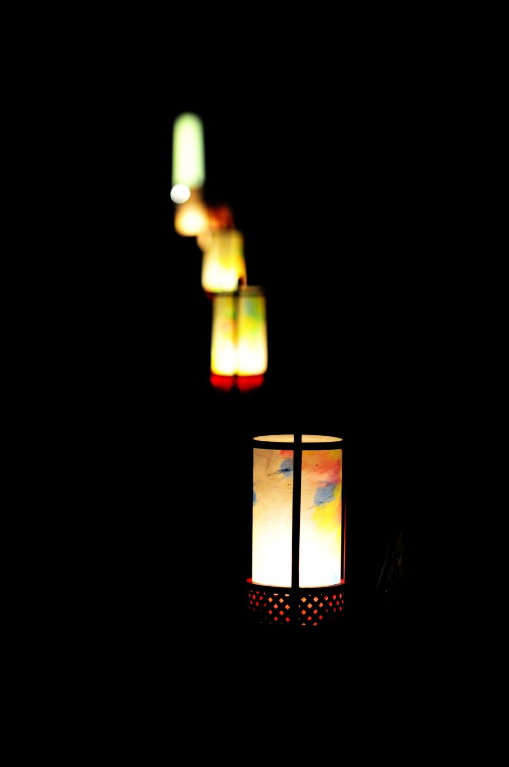 Lit-up lanterns placed regularly alongside the pathway