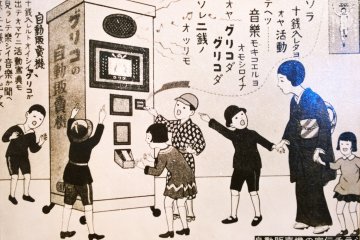 <p>ภาพโฆษณาในอดีตของ Glico Vending Machine with Built-in Movie ที่ลงในหนังสือพิมพ์</p>