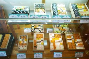 รูปอาหารจำลองด้านหน้าร้านชั้นล่างที่โชว์ให้เห็นความหลากหลายของความอร่อยในสไตล์ซูชิกล่องของ&nbsp;Yoshino Sushi (吉野寿司)
