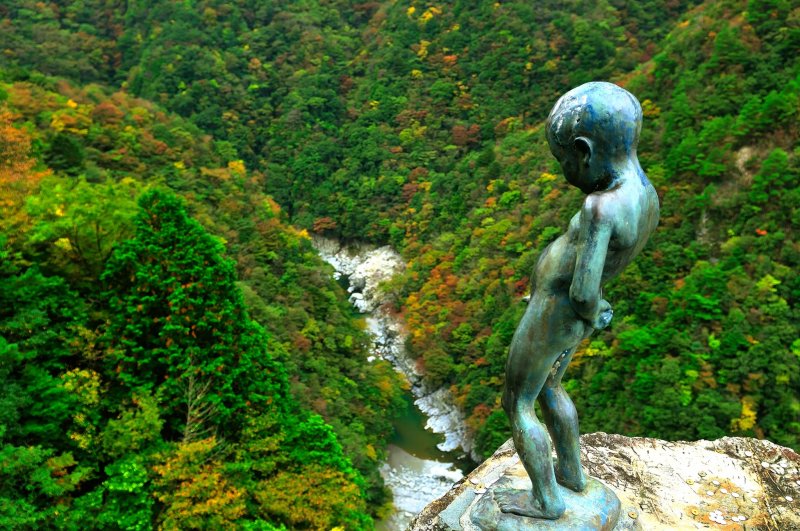<p>He is peeing from the edge of a cliff! How audacious!</p>