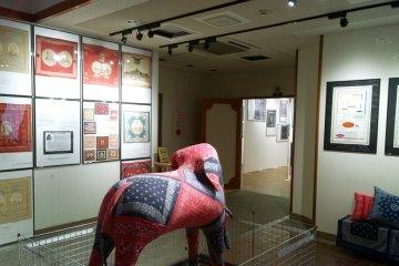 <p>โถงทางเข้าของ The Elephant Brand Bandanna Museum ที่จัดแสดงเรื่องราวต่างๆ ของผ้าพันคอผืนสี่เหลี่ยมจตุรัสนี้ไว้อย่างน่าสนใจ ซึ่งทั้งหมดเป็นของสะสมของ&nbsp;Kiro Hirata เจ้าของแบรนด์ KAPITAL ยีนส์ญี่ปุ่นที่ดังระดับโลกนั่นเอง</p>