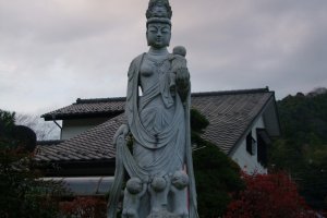 A tall statue of Kannon, with children