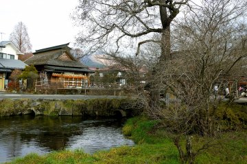 Дома с соломенными крышами, вода и деревья в Осино Хаккай 