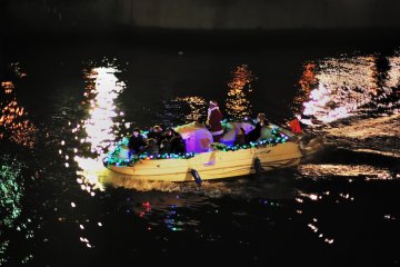 <p>Illuminated boat floating on Dojima River going under Yodoyabashi and Ooebashi Bridges</p>