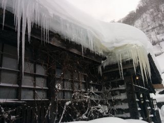 Icicles hang from the eaves of snow-covered roofs