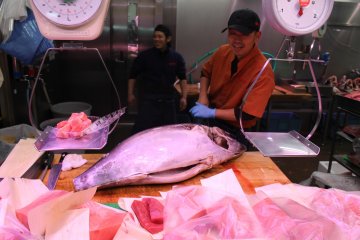 <p>Cutting up tuna for sale in front of the customers</p>