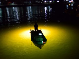 光芒に浮かぶ漁船（新町川）