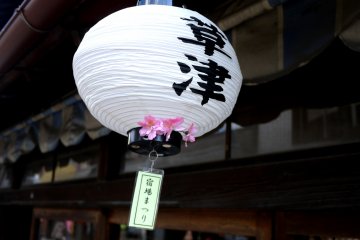 <p>Paper lanterns decorated with blossom and the characters for Kusatsu hung from all the shop awnings</p>