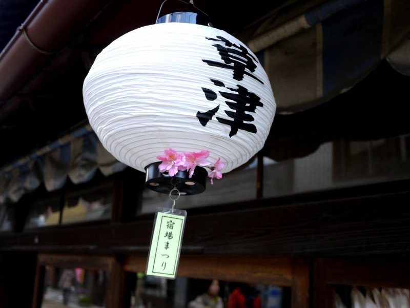 <p>Paper lanterns decorated with blossom and the characters for Kusatsu hung from all the shop awnings</p>