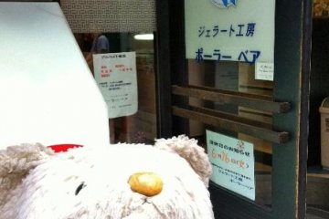 stuffed bear and sign in front of shop