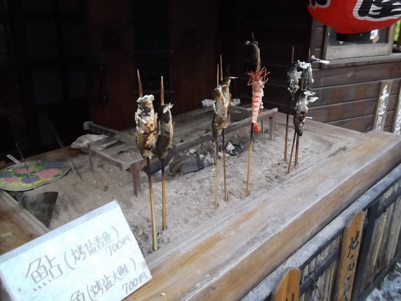 <p>There are lots of places to buy snacks, like barbequed fish on a stick</p>