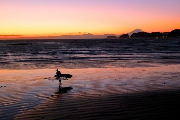 <p>A lonely surfer about to call it a day, Mt. Fuji, and a beautiful sunset</p>