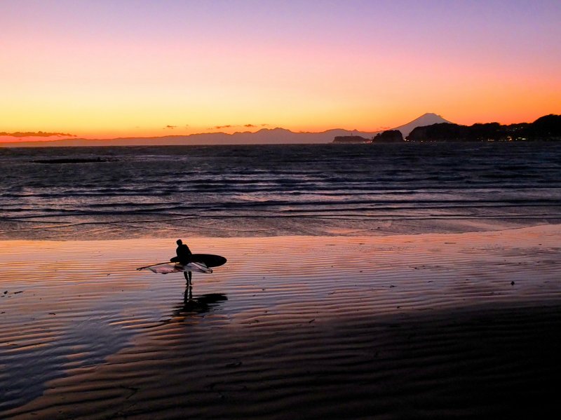 <p>A lonely surfer about to call it a day, Mt. Fuji, and a beautiful sunset</p>