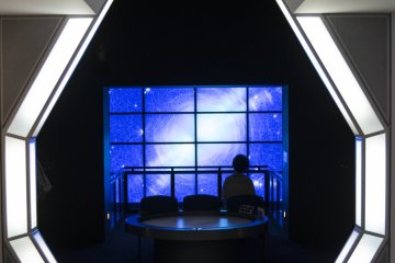 <p>A large video screen at the end of the space-themed permanent exhibition section.</p>