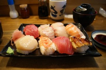 A plate of sushi at a formal sushi restaurant; notice the wasabi (bottom left) and shoga (left)