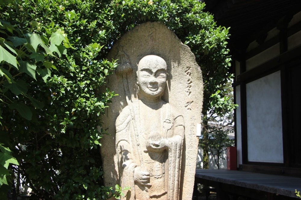 Каменная статуя на территории Денко-дзи